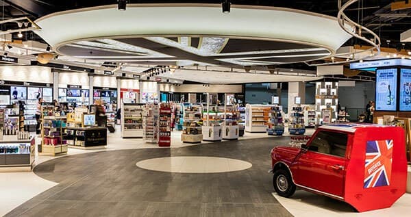 An airport travel retail store, with a red Mini painted in a Union Jack livery parked on the shop floor