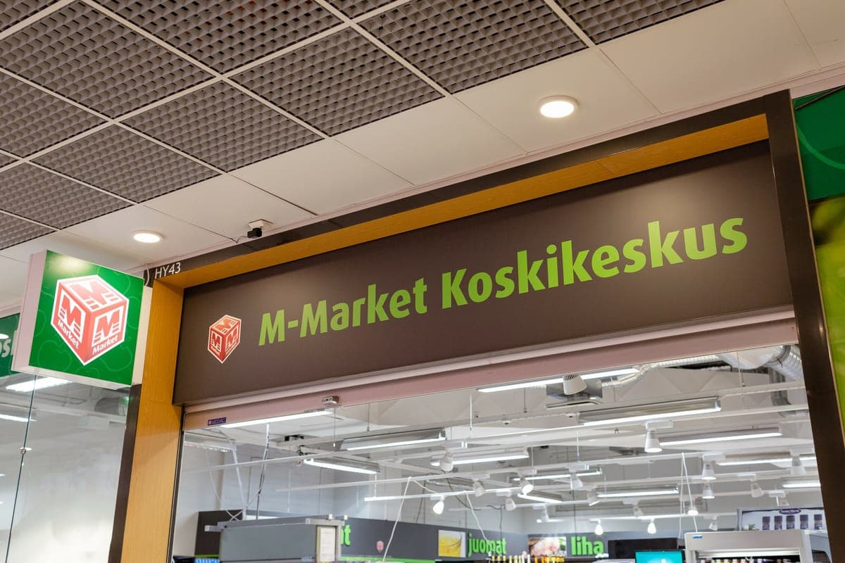 The entrance sign of the M-Market Koskikeskus supermarket, with the store visible through the glass
