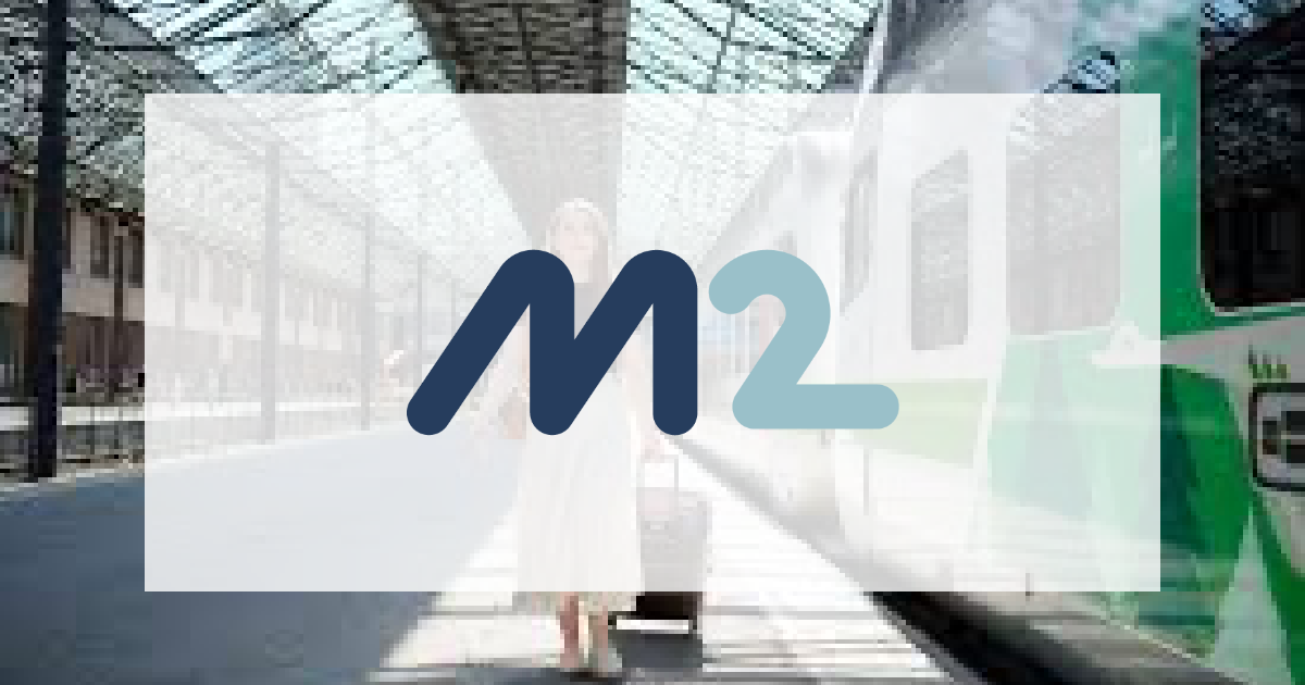 The Visma M2 logo over a faded photo of a traveller with a suitcase on a station platform