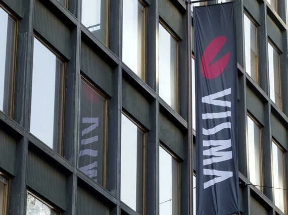 Two Visma banners hanging from a modern office facade