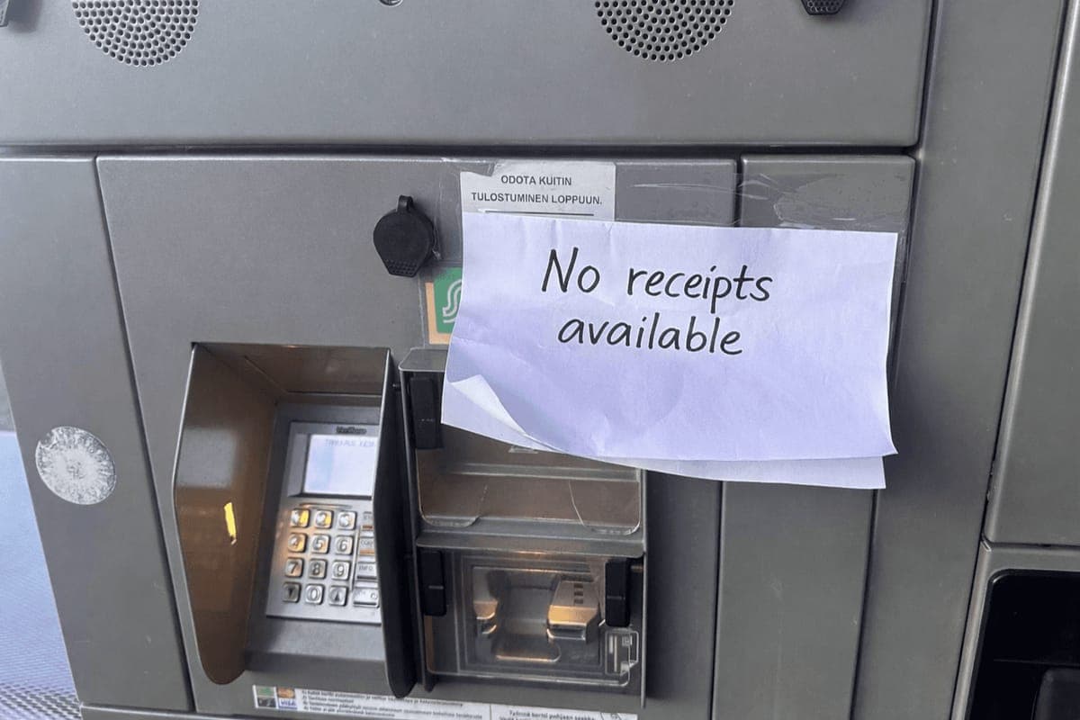 A handwritten sign reading No receipts available taped over the printer slot of a self-service fuel terminal