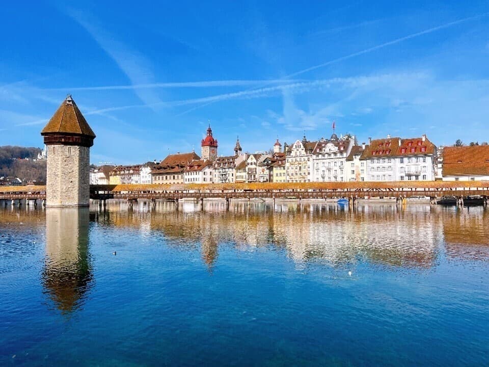 The old town of Lucerne across the water, with the Water Tower and the Chapel Bridge in the foreground