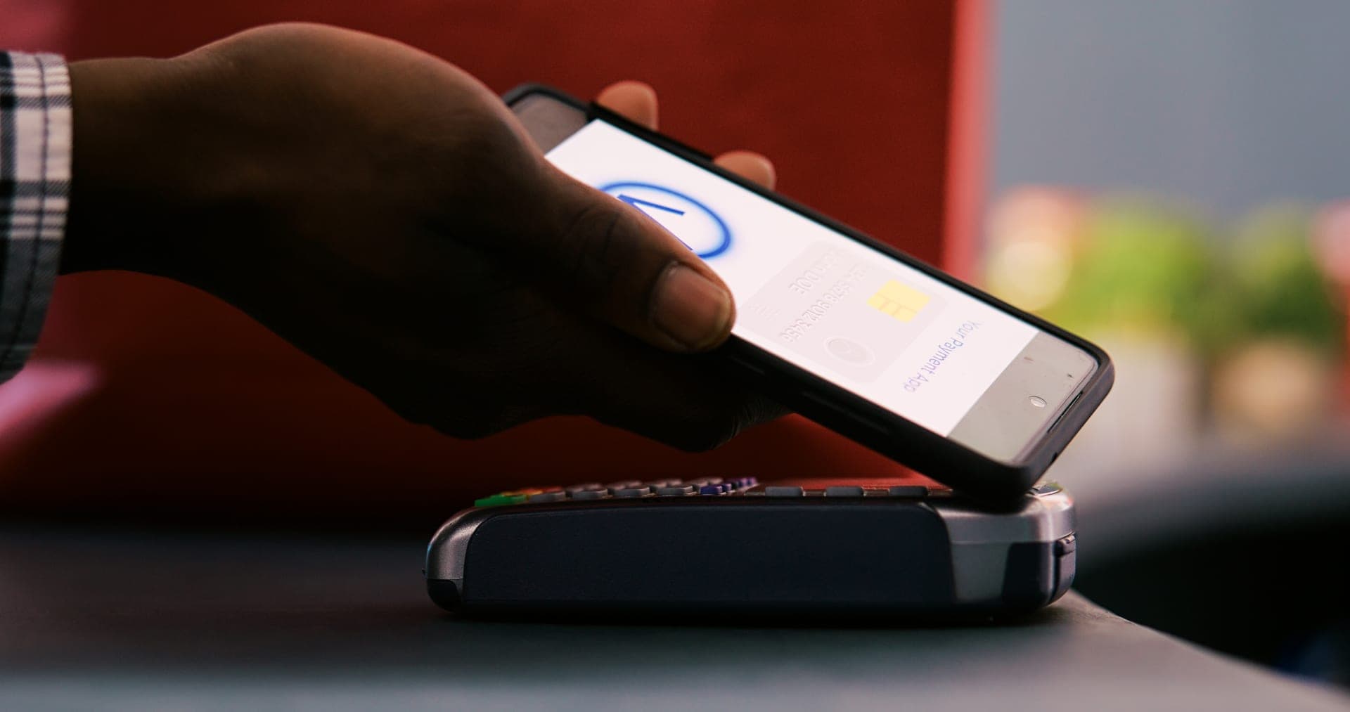 Customer tapping phone on payment terminal for NFC receipt